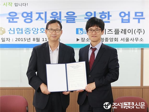 주진우 신협중앙회 기획관리이사(사진에서 좌측)와 윤완수 비즈플레이(주) 대표이사(사진에서 우측)가 협약서에 서명하고 기념촬영을 하고 있다.