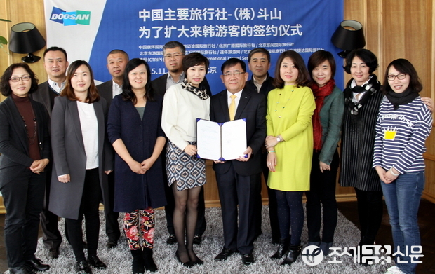 (주)두산은 2일(현지시각) 중국 베이징에서 두타 조용만 대표(앞줄 왼쪽에서 다섯 번 째)와 강호이여행사, CTRIP, CYTS 등 중국의 주요 여행사 14개 관계자들이 참석한 가운데 ‘방한 요우커 확대를 위한 업무협약’을 체결했다. <사진제공=㈜두산>