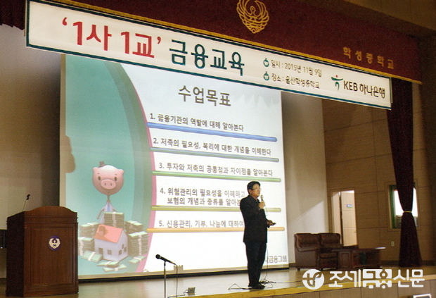 퇴직 직원 김근생 前지점장(사진 강단 위)이 학생들에게 금융거래에 필수적인 기초 상식에 대해 강의하고 있다.