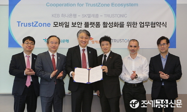 KEB하나은행은 지난 26일 SK텔레콤, 영국 Trustonic 社와 모바일 보안 플랫폼 활성화를 위한 업무협약식을 갖고 최고수준의 모바일 보안시스템 공동 구축에 합의했다. 한준성 KEB하나은행 미래금융그룹 전무(사진 왼쪽에서 세번째)와 조응태 SKT 상품기획본부장(사진 왼쪽에서 네번째)이 행사 관계자들과 기념촬영을 하고 있다.
