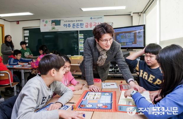 아주캐피탈 직원이 지구촌학교 학생들과 함께 용돈관리 보드게임을 하며 ‘아주 든든한 금융교육’수업을 하고 있다.