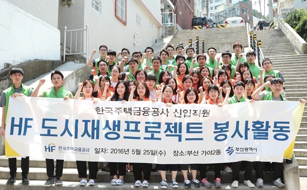 주택금융공사 신입 직원들이 25일 부산시 진구 가야2동 일대에서 ‘HF도시재생프로젝트’에 참여해 주거환경 개선작업에 나섰다. 봉사활동에 앞서 신입직원들이 기념촬영을 하고 있다.