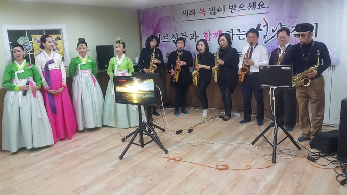 지난 21일 이종탁 한국세무사회 부회장(오른쪽에서 세번째)이 설을 맞아 어르신들이 생활하는 요양시설을 방문, 색소폰 위문공연을 펼치고 있다.